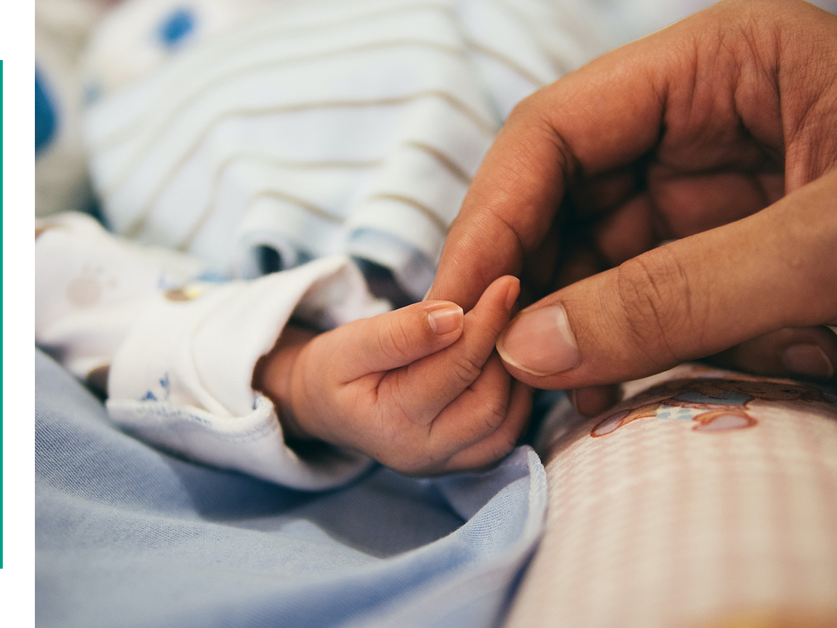 parent holding baby's tiny hand